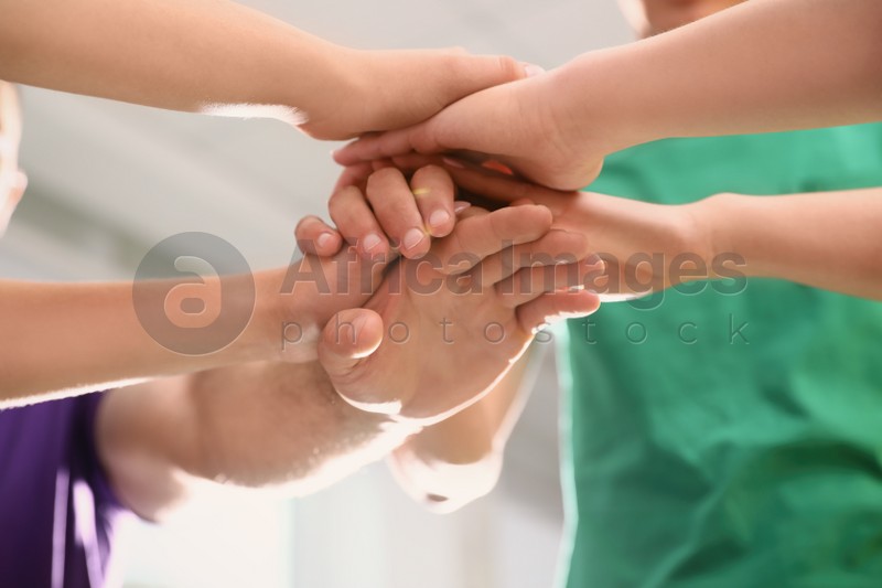 Group of volunteers joining hands together, closeup