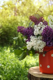 Bouquet of beautiful lilac flowers in milk can outdoors