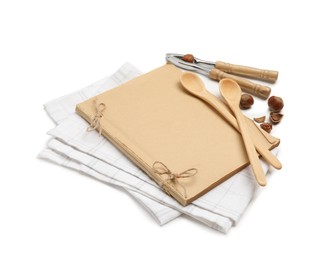 Blank recipe book, napkin, nuts and wooden utensils on white background. Space for text