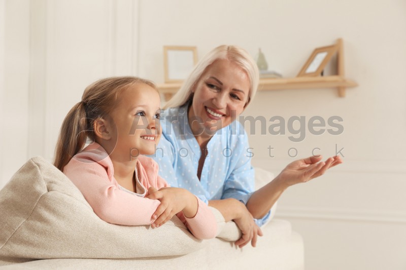 Happy grandmother spending time with her granddaughter at home
