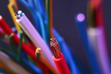 Colorful cables on blurred background, closeup. Electrician's supply