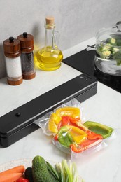 Sealer for vacuum packing with plastic bag of bell pepper on counter in kitchen