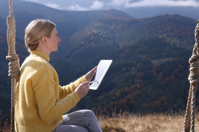 Young woman drawing with graphic tablet in mountains