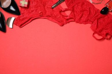 Stylish set with sexy women lingerie on red background, flat lay. Space for text