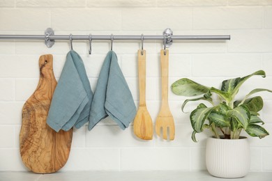 Clean towels and utensils hanging on rack in kitchen