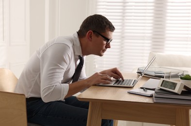 Man with bad posture working on laptop in office