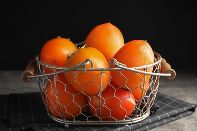 Delicious fresh persimmons on grey table, closeup