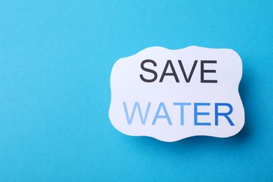 Photo of Sheet of paper with words Save Water on light blue background, top view. Space for text