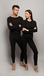 Couple wearing thermal underwear on grey background