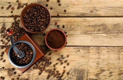Photo of Vintage manual coffee grinder with beans and powder on wooden table, flat lay. Space for text