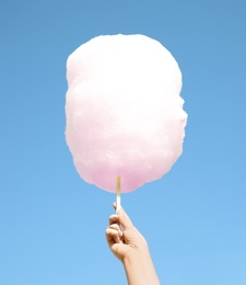 Photo of Woman holding white cotton candy against blue sky