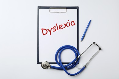 Image of Clipboard with word Dyslexia, pen and stethoscope on white background, top view