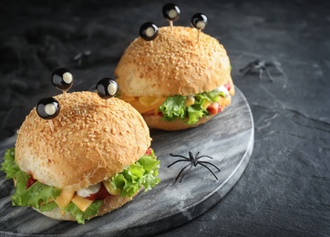 Cute monster burgers served on black table. Halloween party food
