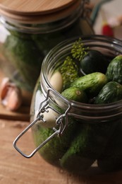 Jar with cucumbers, garlic and dill on wooden table, closeup. Pickling recipe