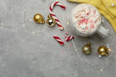 Photo of Flat lay composition with delicious marshmallow drink, festive decor and yellow sweater on light grey table. Space for text
