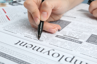 Woman marking advertisement in newspaper, closeup. Job search concept