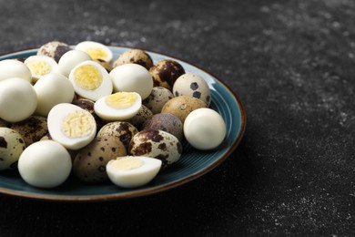 Photo of Peeled and unpeeled hard boiled quail eggs in plate on black table, closeup. Space for text