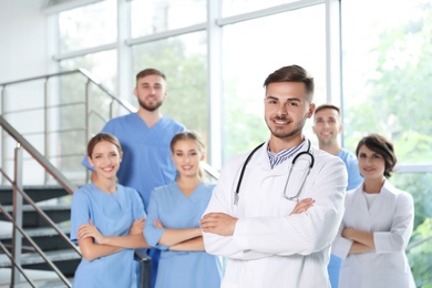 Portrait of male doctor and his colleagues at workplace