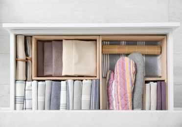 Open drawer with different textiles in kitchen, top view