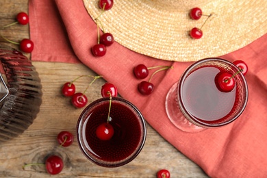 Delicious cherry wine with ripe juicy berries on wooden table, flat lay