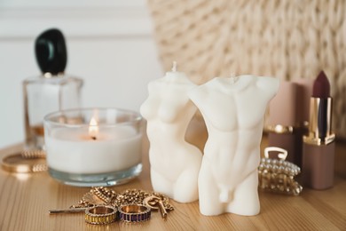 Beautiful female and male body shaped candles on wooden table. Stylish decor