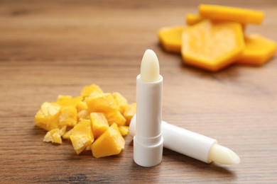 Hygienic lipsticks and natural beeswax on wooden table