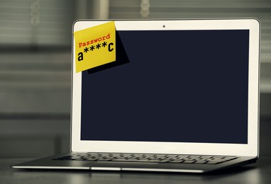Sticky note with password on laptop indoors. Space for text