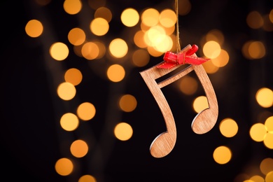 Wooden notes against blurred lights, space for text. Christmas music