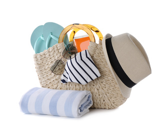 Bag with different beach objects and towel on white background