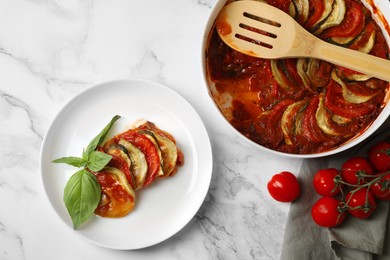 Photo of Delicious ratatouille served with basil on white marble table, flat lay