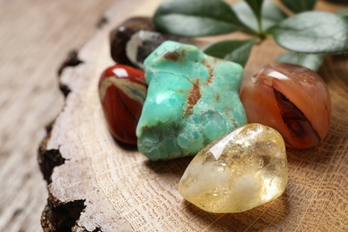 Photo of Citrine quartz and beautiful gemstones on wooden stand, closeup
