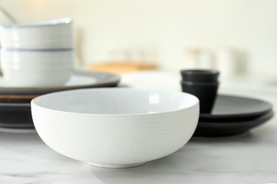 Clean ceramic bowl on white marble table in kitchen, closeup