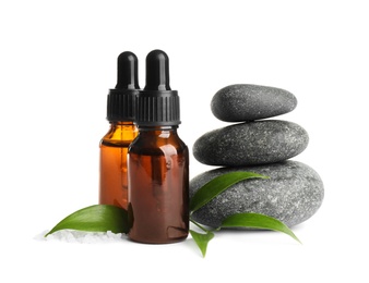 Composition with aroma oil and spa stones on white background