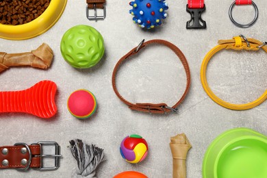 Flat lay composition with dog collars, toys and food on grey background
