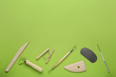 Photo of Set of clay modeling tools on green background, flat lay. Space for text