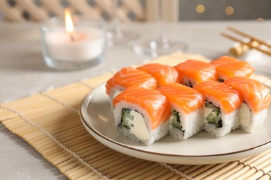 Tasty sushi rolls on grey table against blurred lights, closeup. Space for text