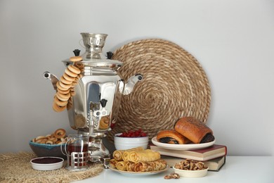 Traditional Russian samovar with treats on white table
