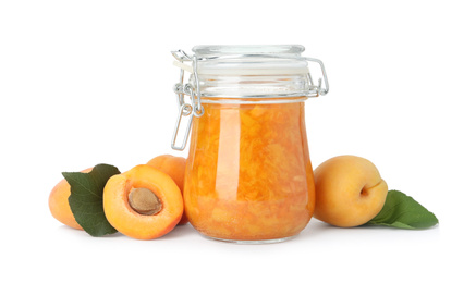 Jar of apricot jam and fresh fruits on white background