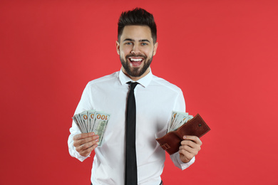 Emotional young man with money and wallet on crimson background