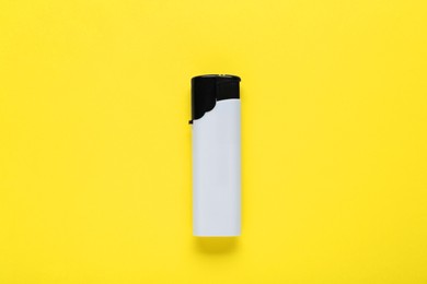 Photo of Stylish small pocket lighter on yellow background, top view
