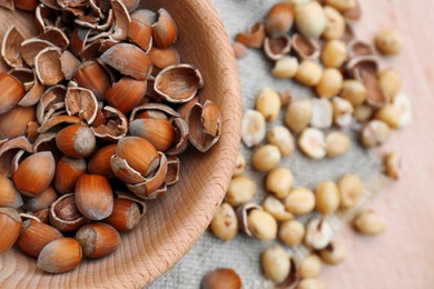 Photo of Bowl with tasty organic hazelnuts on table, top view. Space for text