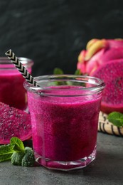 Delicious pitahaya smoothie, fruit and fresh mint on grey table