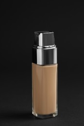 Bottle of foundation on black background. Cosmetic product