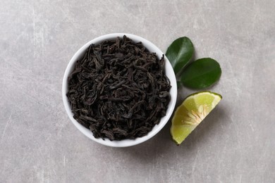 Dry bergamot tea leaves and fresh fruit on light grey table, flat lay