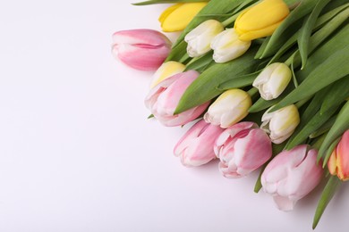 Photo of Beautiful colorful tulips on light background, closeup. Space for text