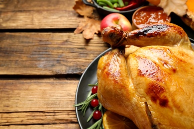 Traditional Thanksgiving day feast with delicious cooked turkey and other seasonal dishes served on wooden table, closeup. Space for text