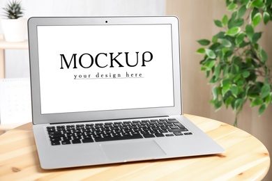 Modern laptop with text Mockup Your Design Here on screen
