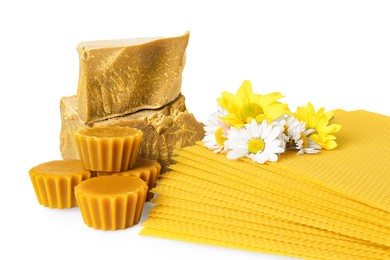 Photo of Different natural beeswax blocks, flowers and sheets on white background