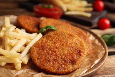 Delicious fried breaded cutlets served on wooden table, closeup