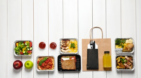 Lunchboxes on white wooden table, flat lay. Healthy food delivery